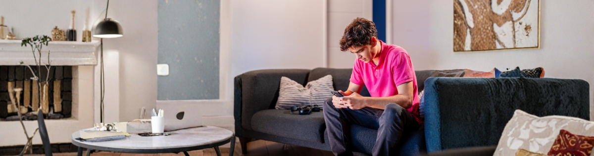 image d'un homme sur un canapé qui regarde son téléphone 